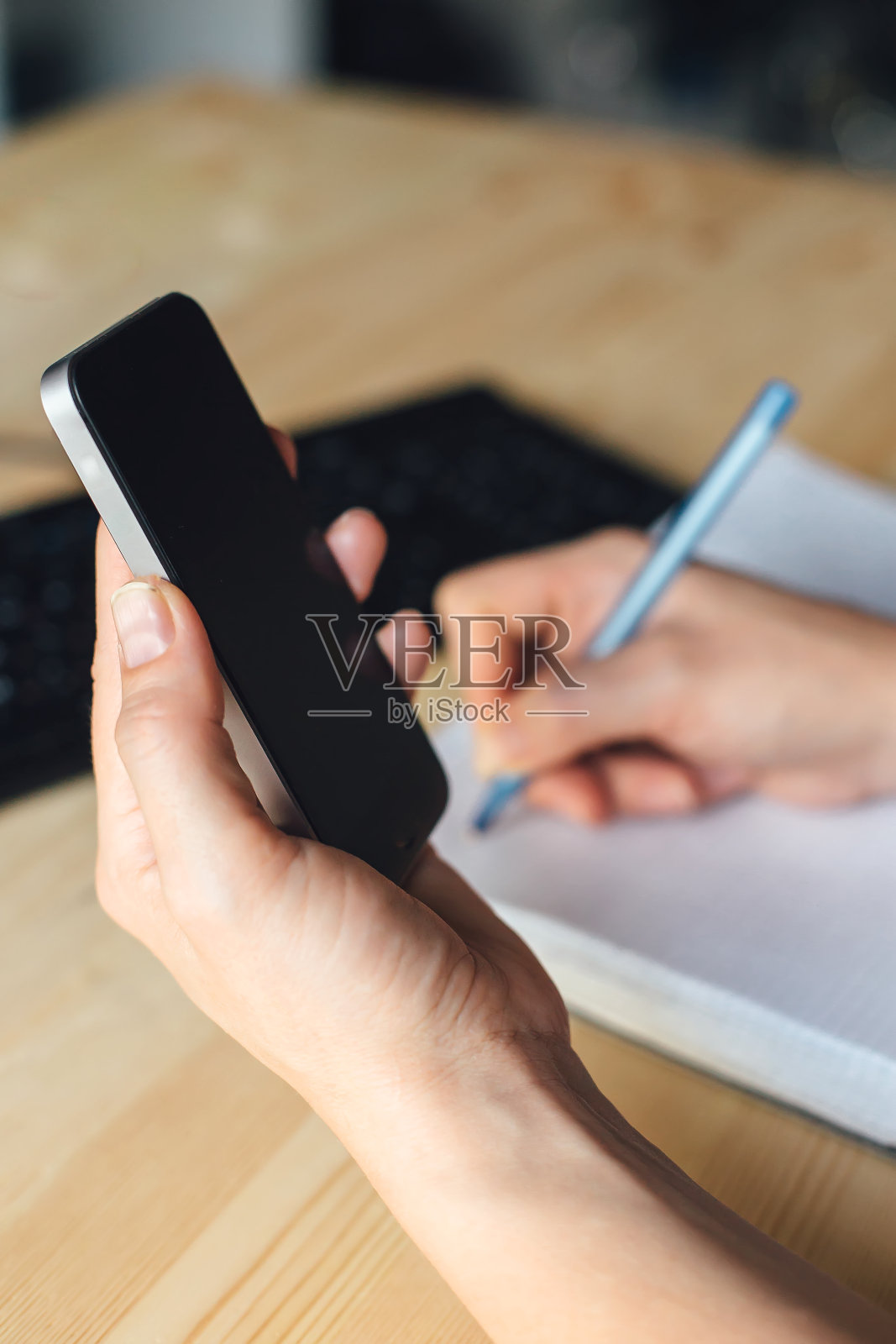 女人用笔在笔记本上写字照片摄影图片