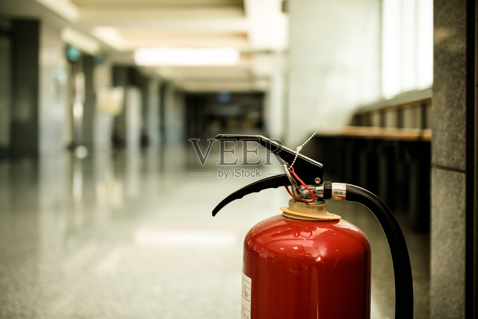 近距离观察现代建筑中的灭火器。主题在右边。照片摄影图片