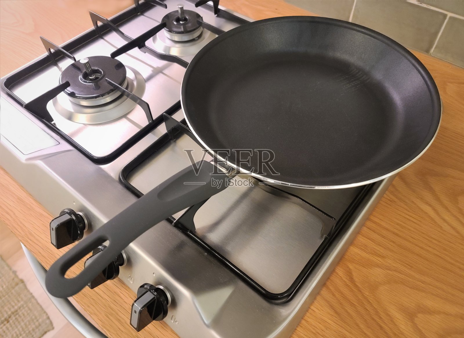 煤气炉上放着一只煎锅。照片摄影图片