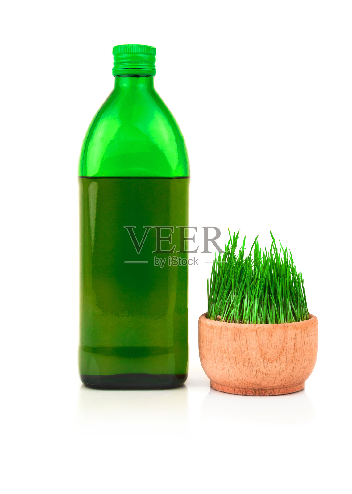 玻璃绿瓶和小麦芽在木碗孤立在白色的背景照片摄影图片