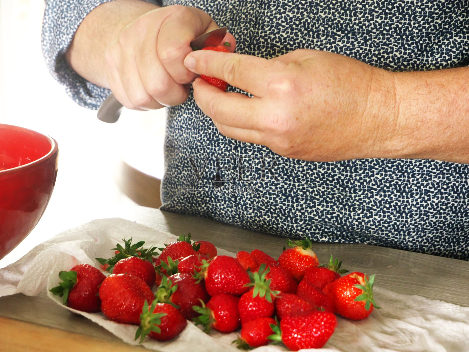 一个男人的手切草莓的特写照片摄影图片