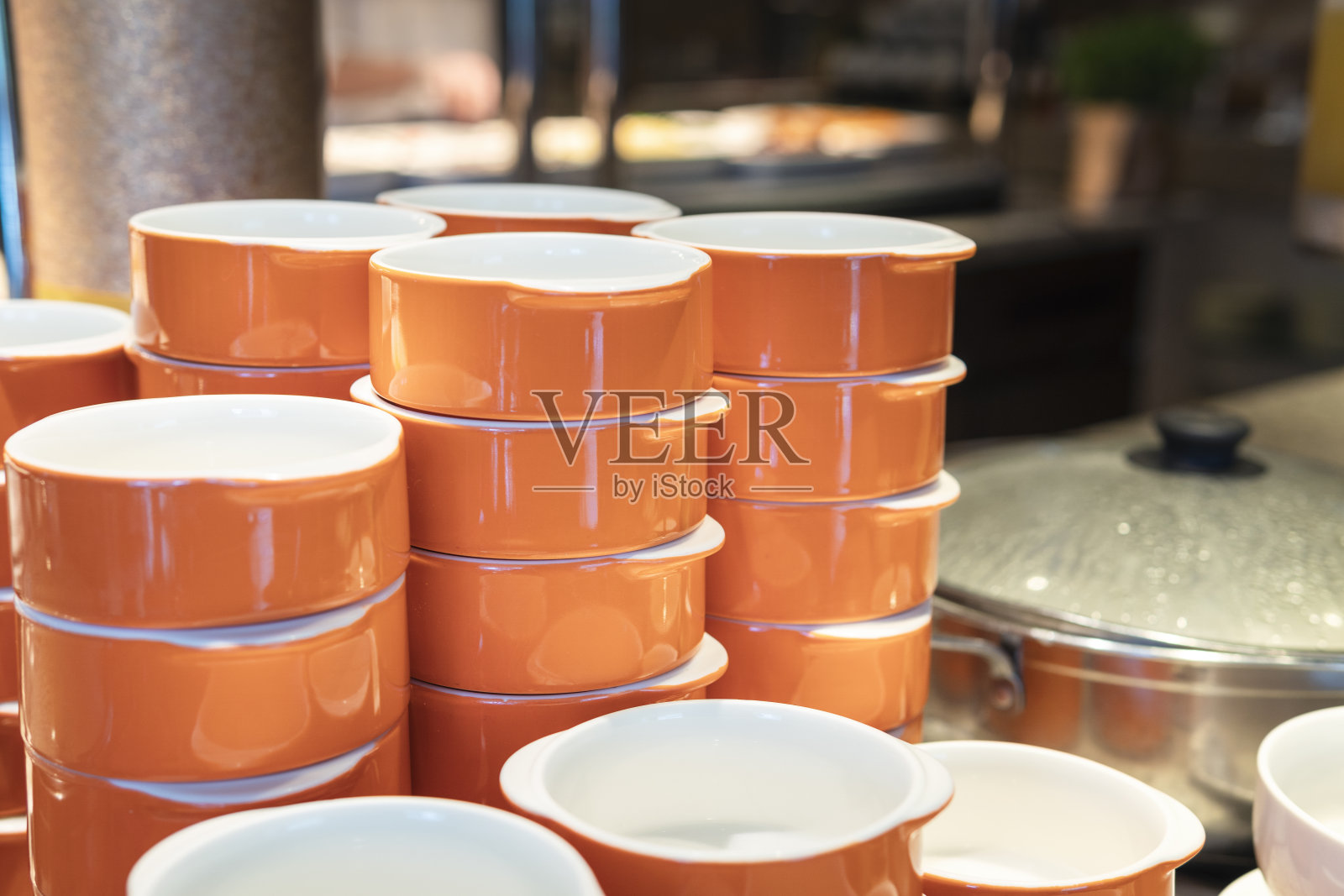 自助餐桌上堆着橙色的碗照片摄影图片