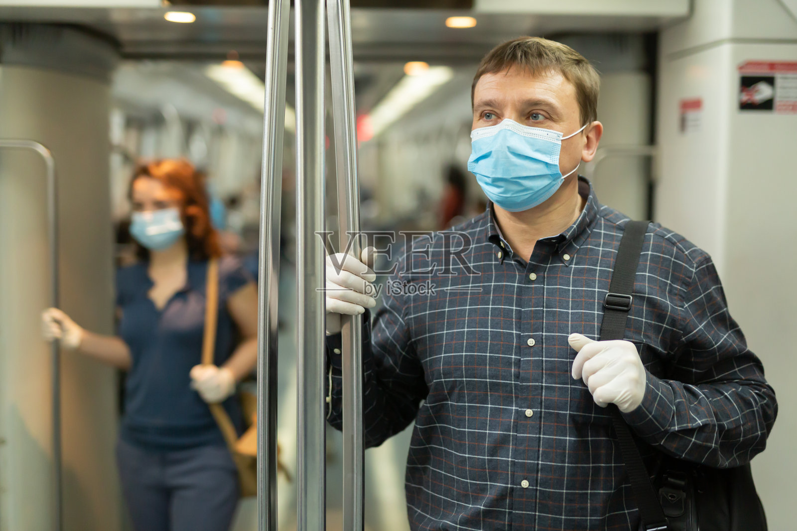戴医用口罩的男男女女在地铁车厢里照片摄影图片