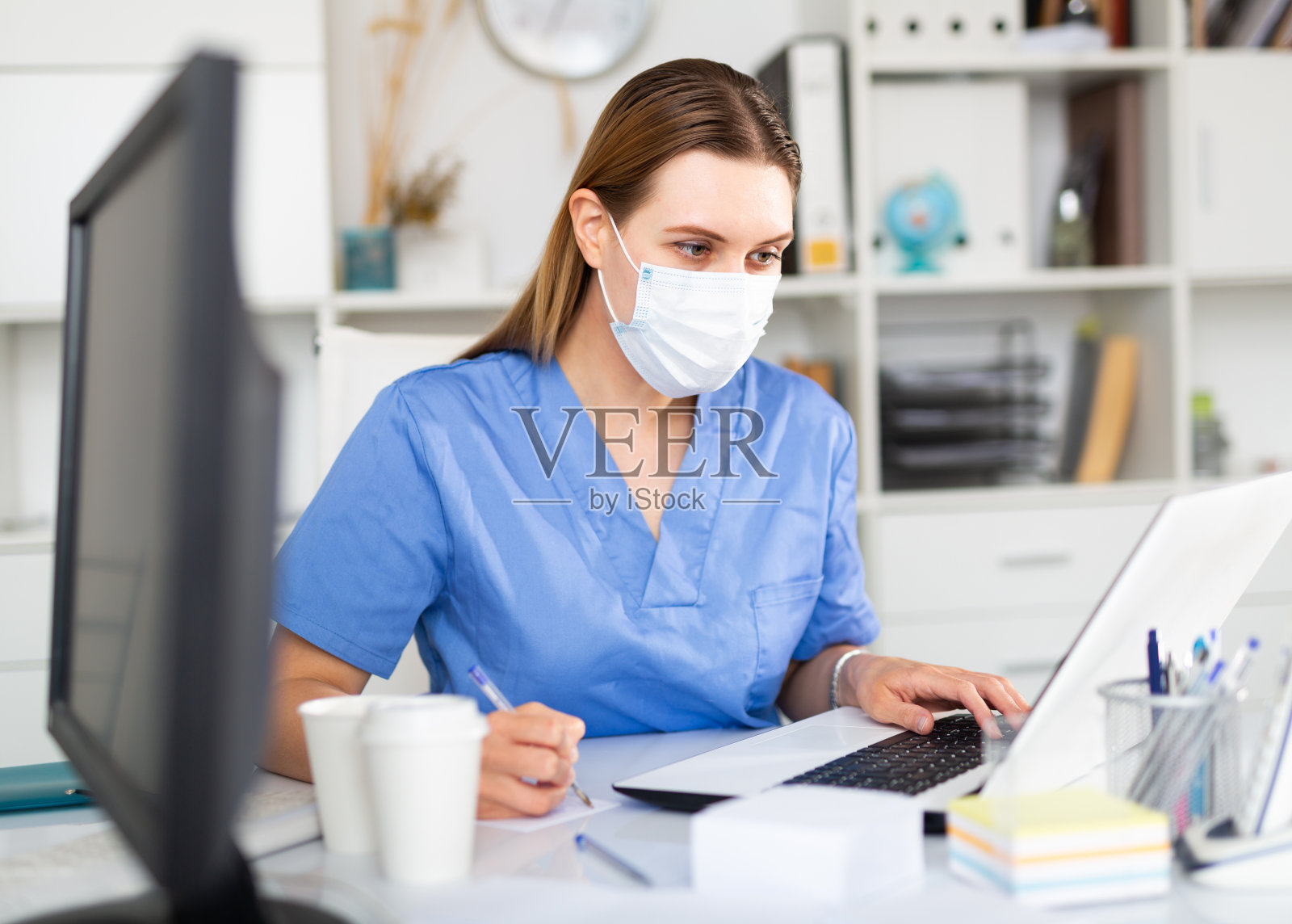 医务人员将病人数据输入笔记本电脑照片摄影图片