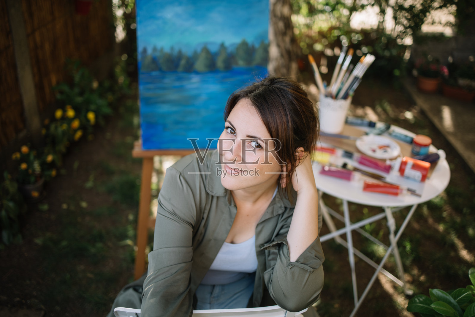 女子画家在花园艺术工作室摆姿势的肖像照片摄影图片