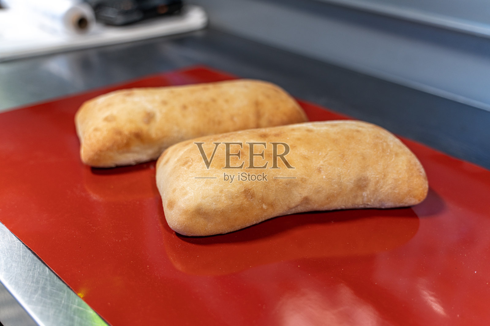 红色的桌子上放着两个新鲜的小面包照片摄影图片