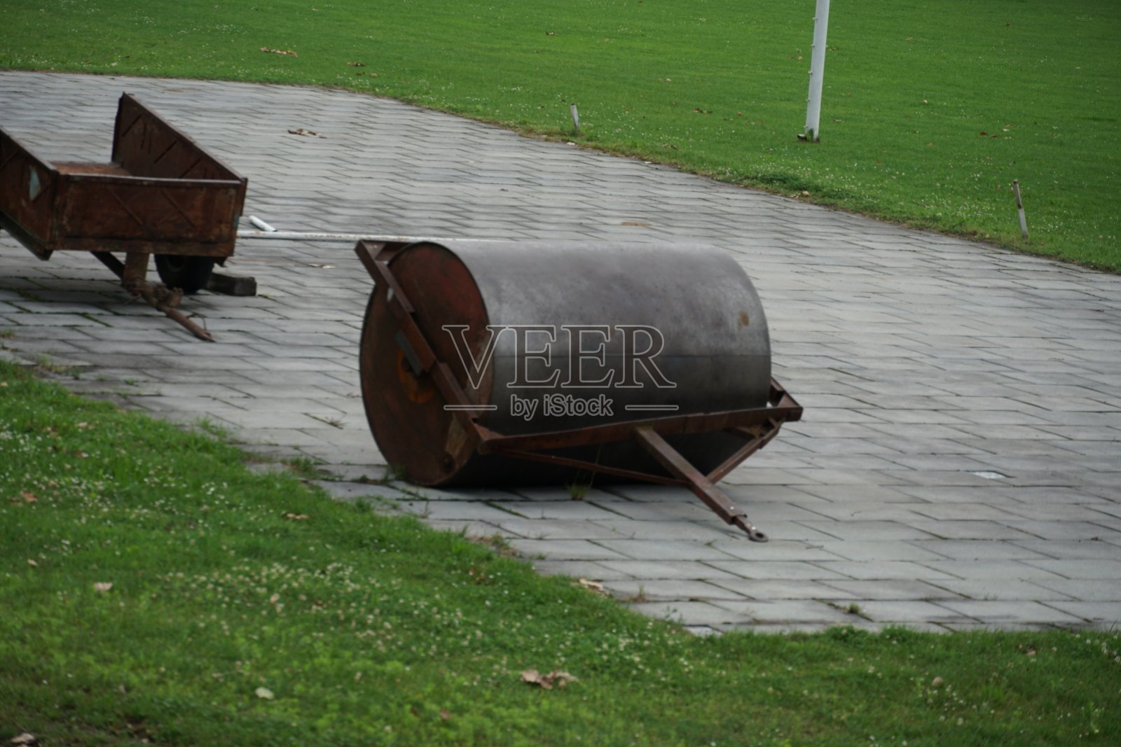 生锈的压路机:用于维护田径跑道的车。它们坐落在东欧一个省城的破旧体育场里。照片摄影图片