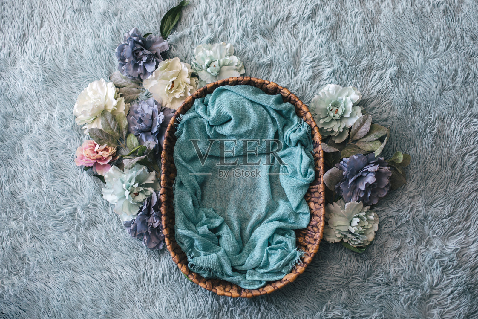 新生花卉背景-蓝绿色人造毛皮编织篮子/碗，蓝绿色，蓝色和粉红色的花环。照片摄影图片