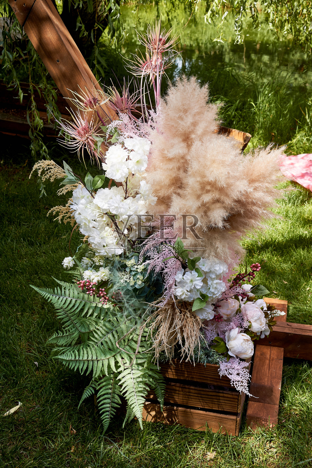 在出境检票处有一部分婚礼木制拱门。婚礼在自然界中。潘帕斯草原，蕨类和干花的组成照片摄影图片
