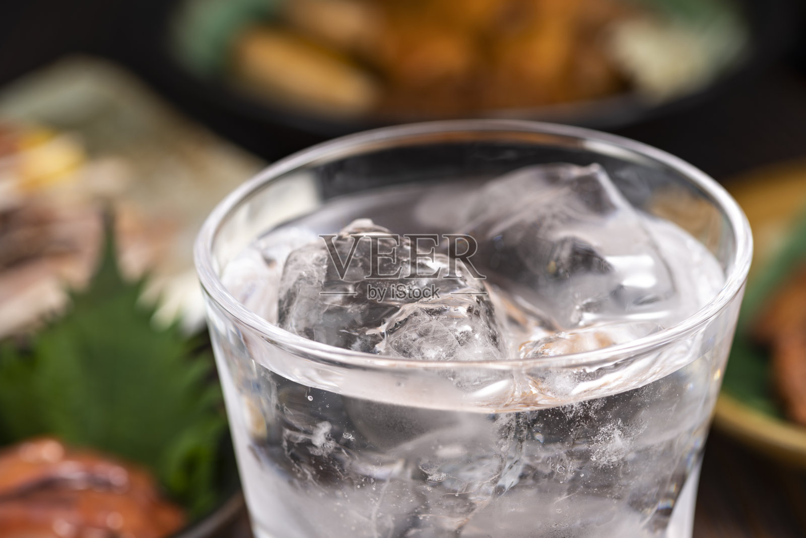 日本酒吧餐厅的美食和饮品。烧酒在岩石上。照片摄影图片