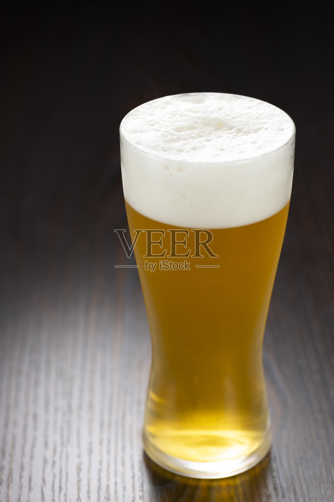 黑木桌上放着生啤酒照片摄影图片