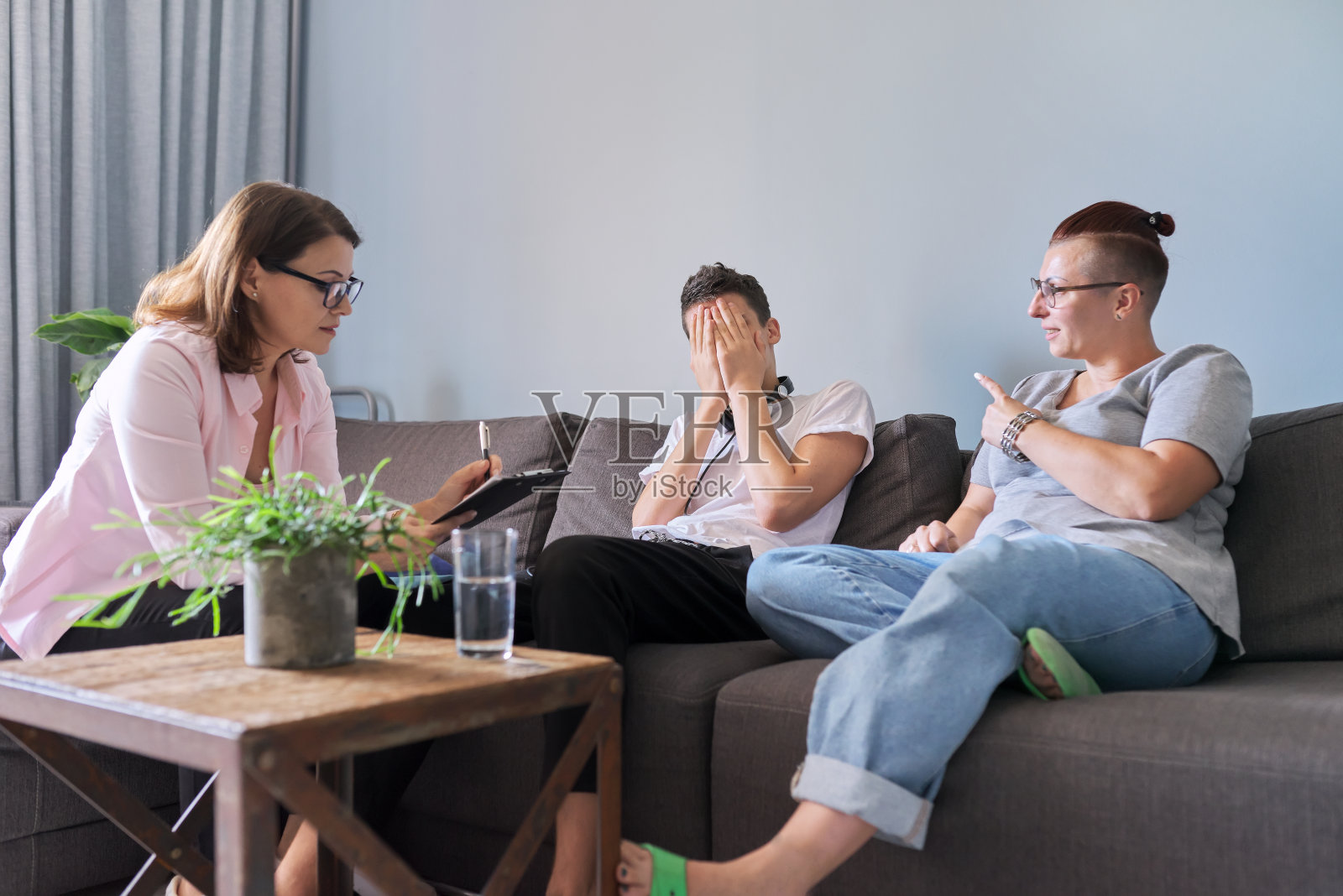 母亲和十几岁的儿子与社工、心理学家会面照片摄影图片