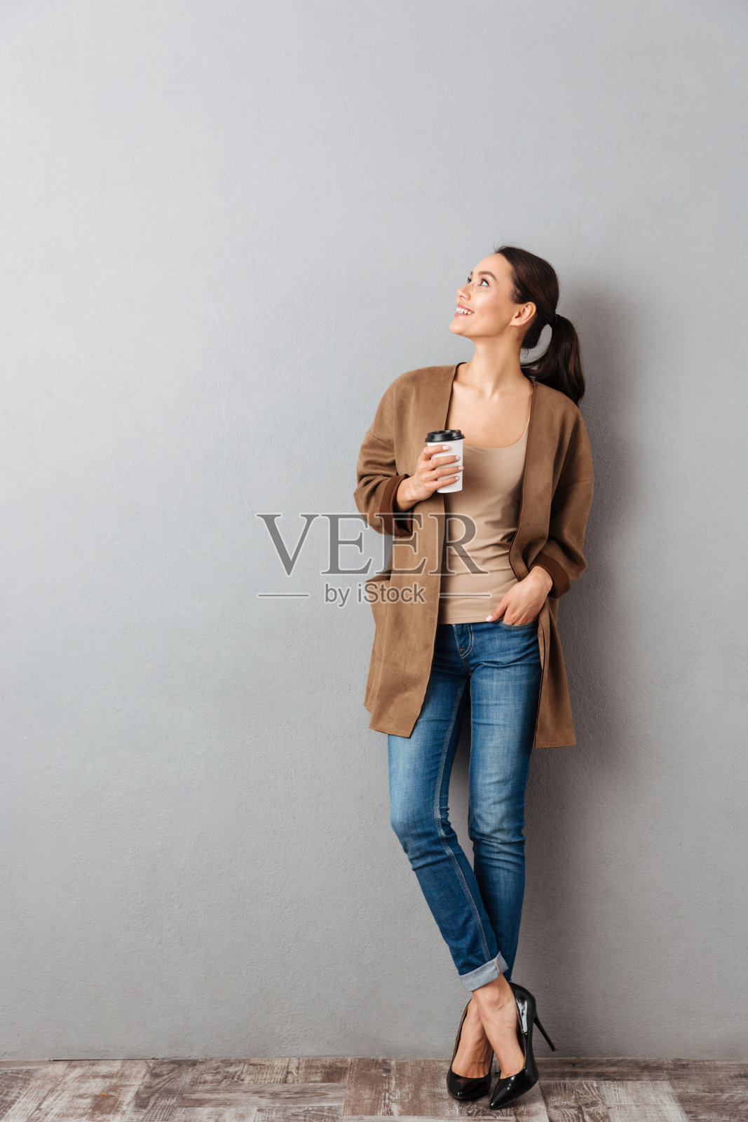 一个看向别处的漂亮年轻亚洲女人的全身长度照片摄影图片