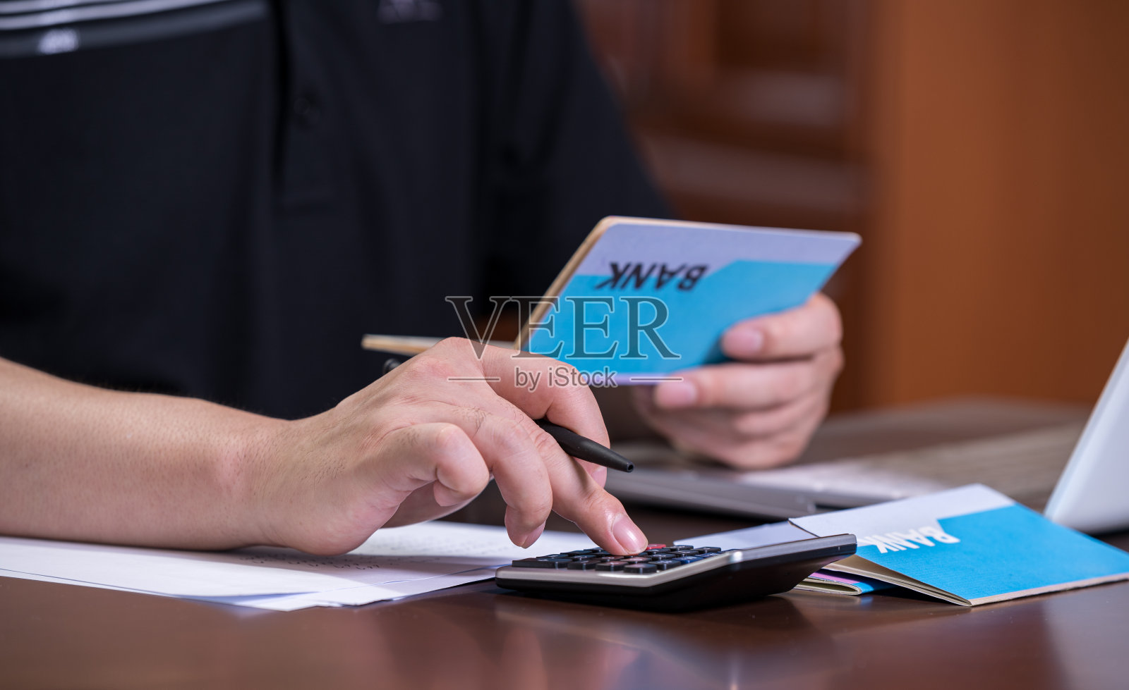 手里拿着银行存折的人正在编制预算。照片摄影图片