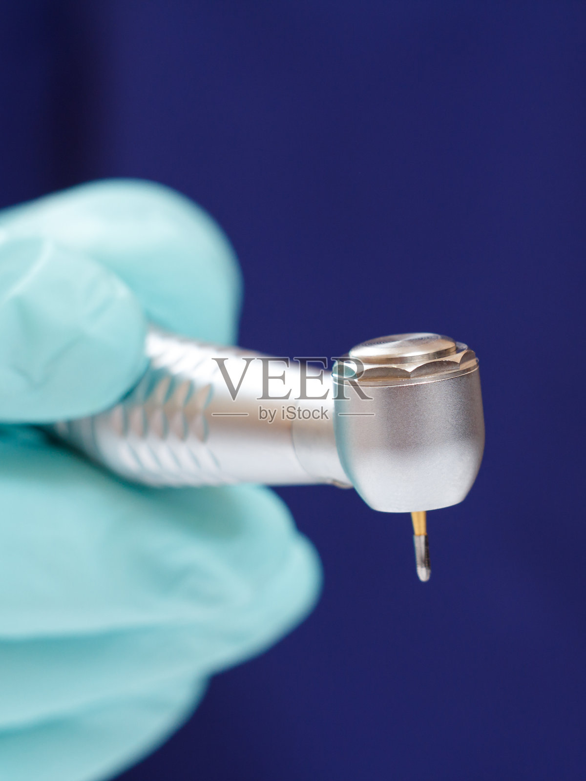 牙医的手戴着手套和牙科电话。照片摄影图片