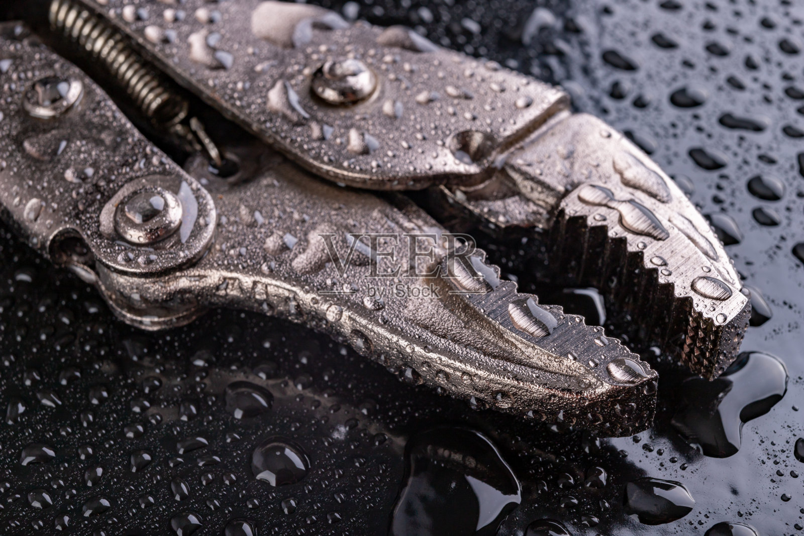 可调液压管扳手盖水。液压技术人员的配件。黑暗的背景。照片摄影图片