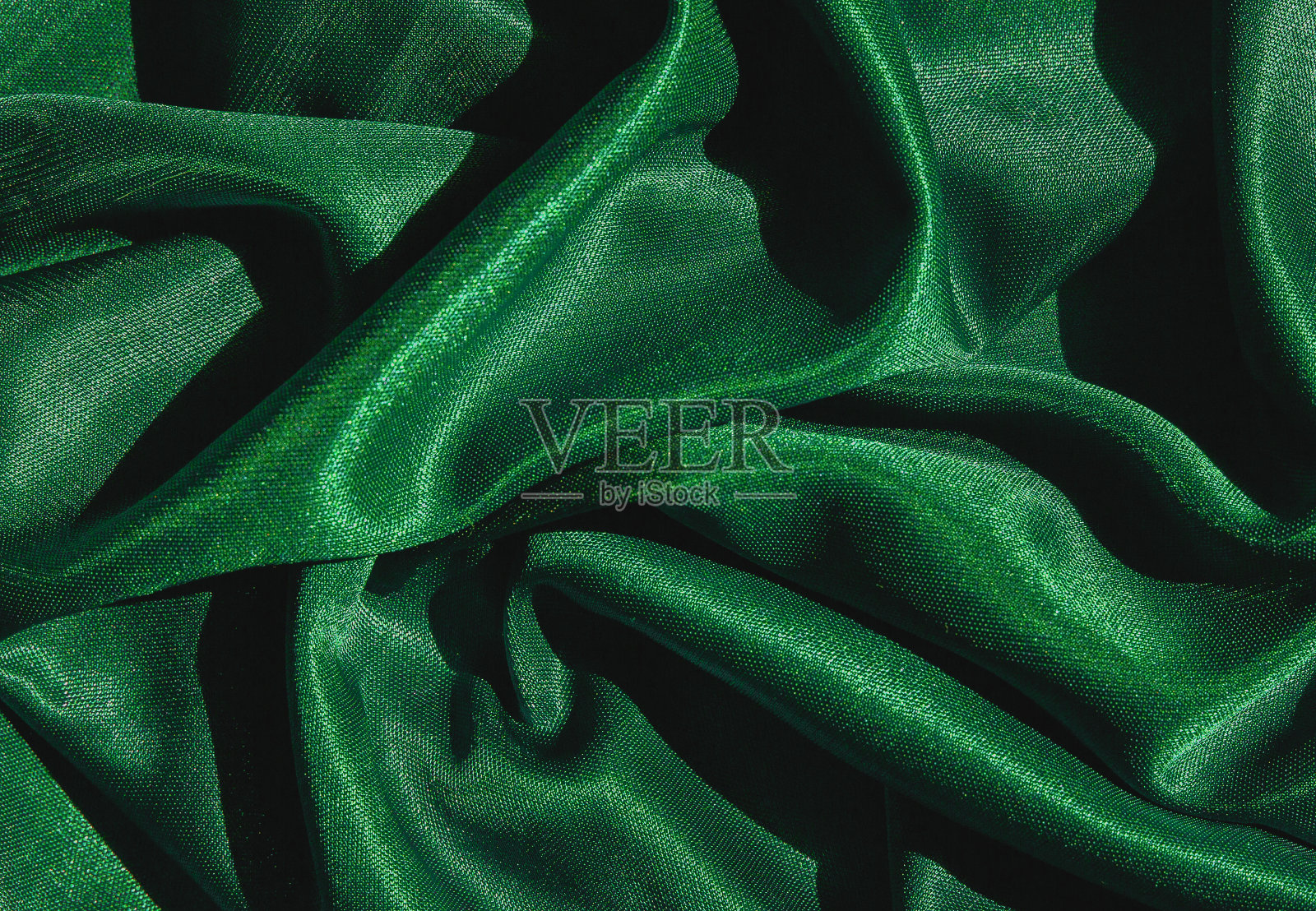 光滑典雅的绿色丝绸或绸缎质地的豪华布料可以用作抽象的背景。奢华的背景设计照片摄影图片