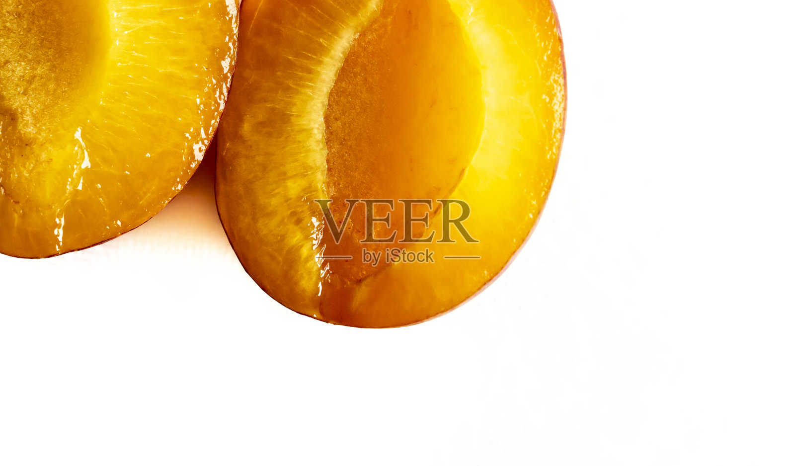 在砧板上切成两半的成熟维多利亚李子照片摄影图片