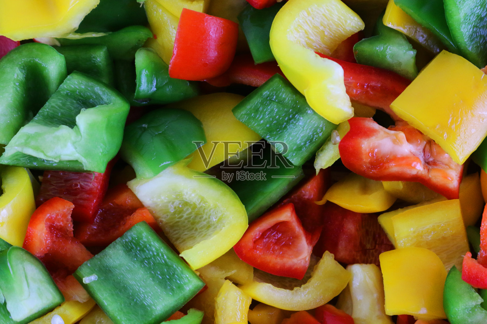 全帧的特写图像，一堆切成小块的混合甜椒，红，绿，黄，高的视野照片摄影图片