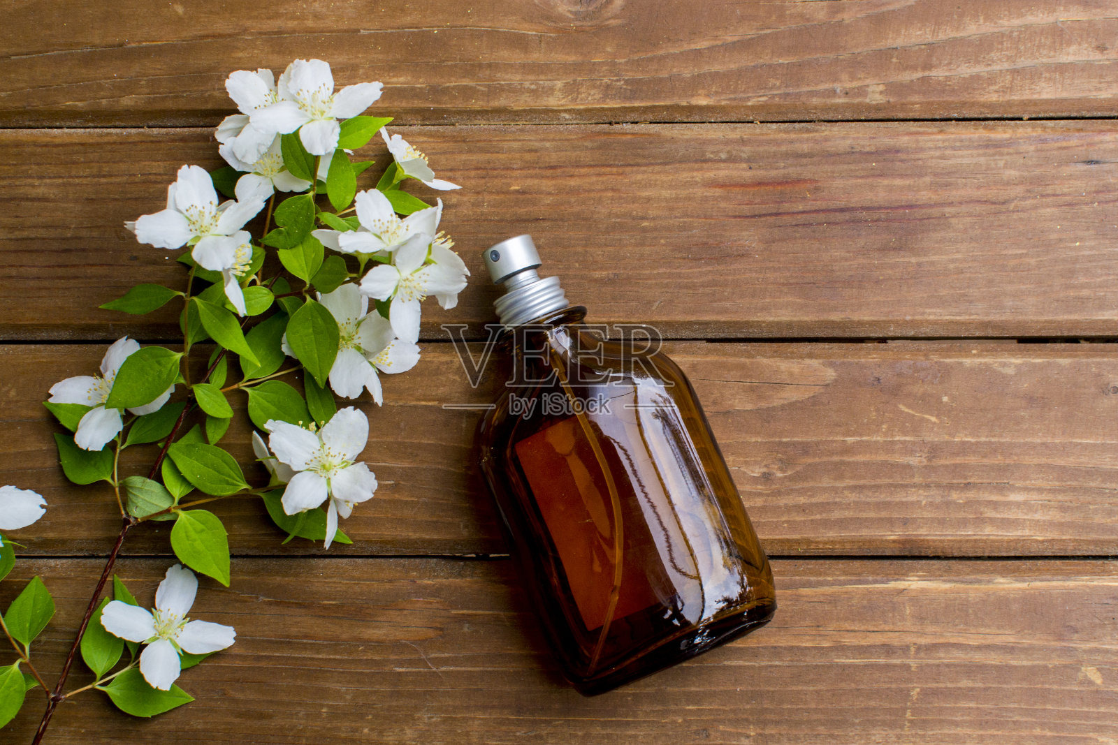 香水。精油。黑暗的玻璃罐。天然的化妆品。天然的香水。花的背景。装有芳香水的瓶子。照片摄影图片