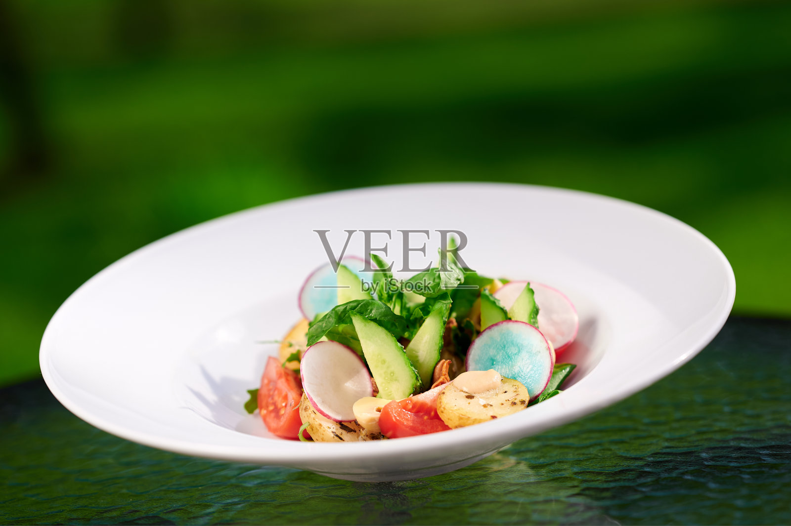 美味的夏季沙拉，新鲜蔬菜在一个白色的盘子，西红柿，萝卜，鳄梨，橄榄照片摄影图片