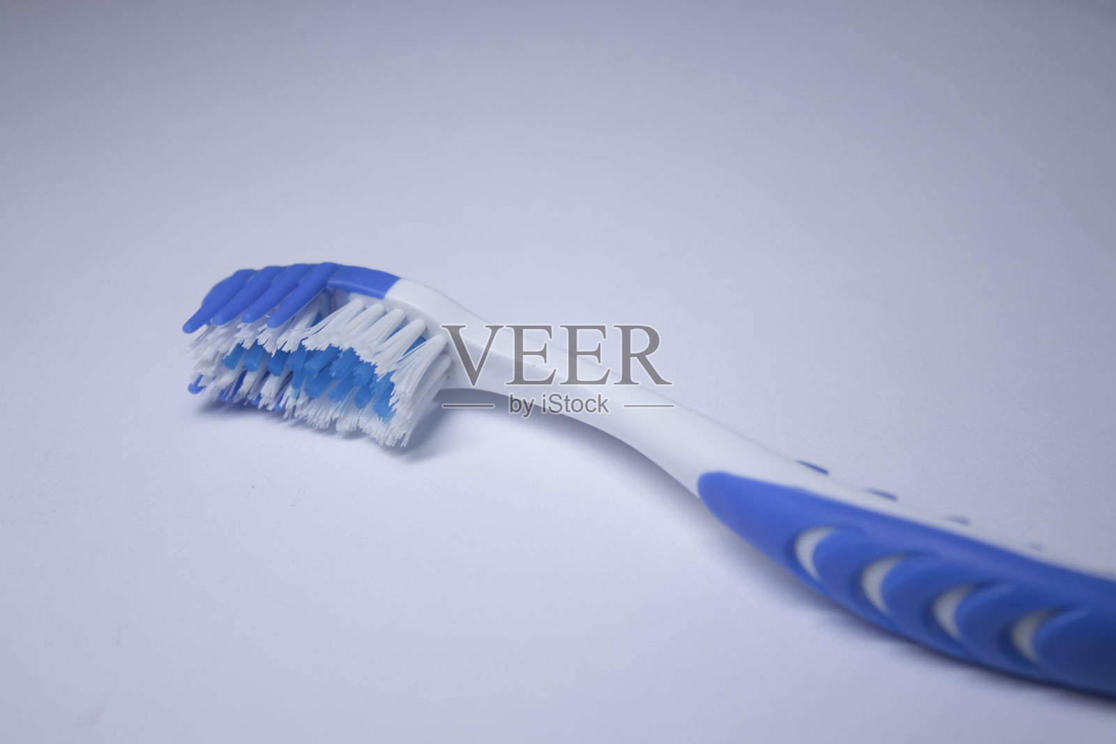 白色背景上的蓝色牙刷。健康清洁牙齿的概念，牙科照片摄影图片