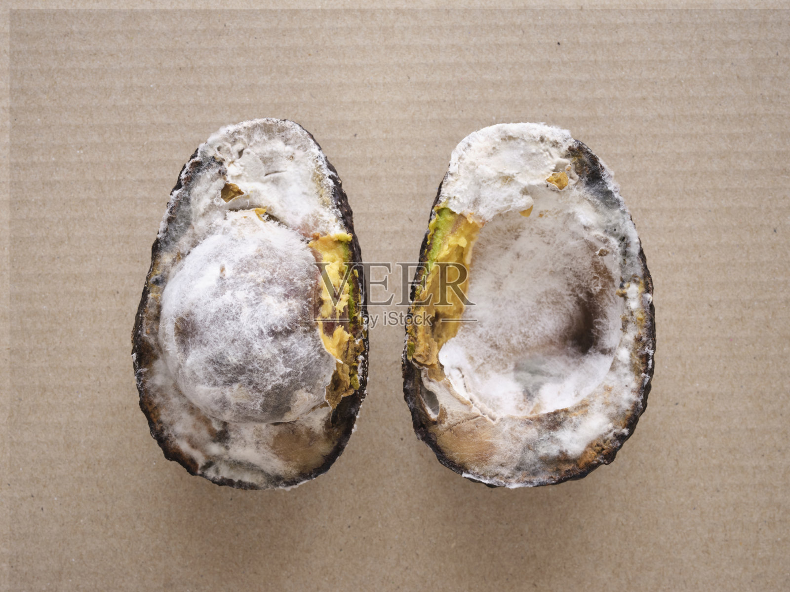 浪费食物。腐烂的鳄梨上长满了霉菌。照片摄影图片