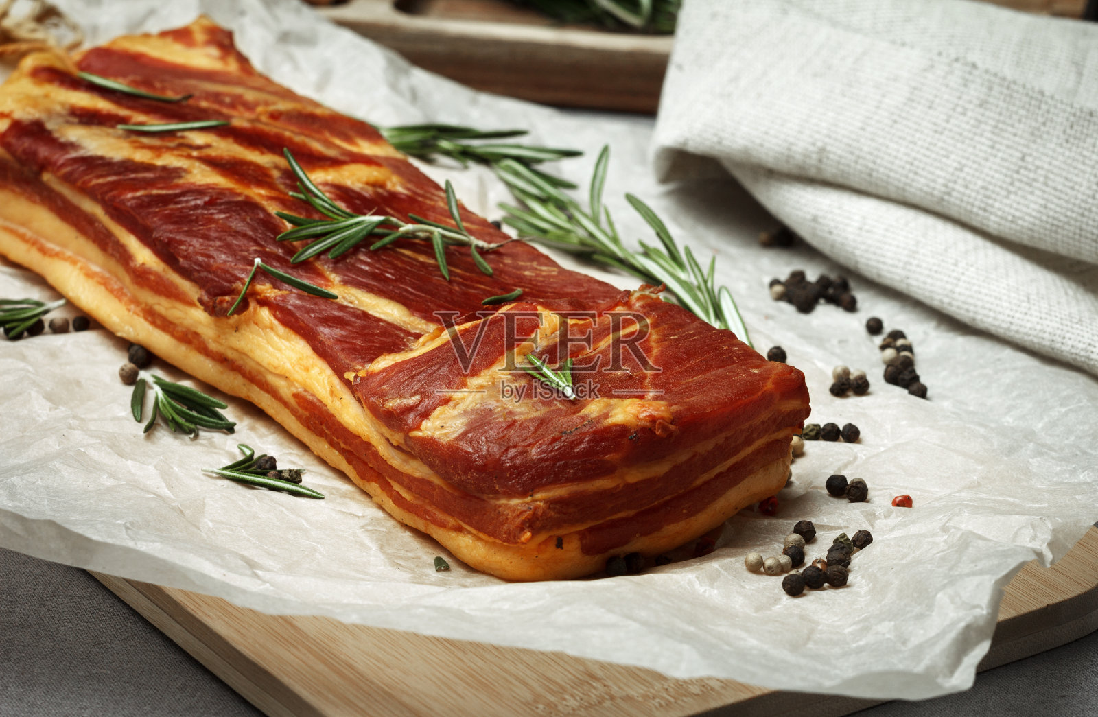 熏猪肉，香草熏肉，放在羊皮纸上。照片摄影图片