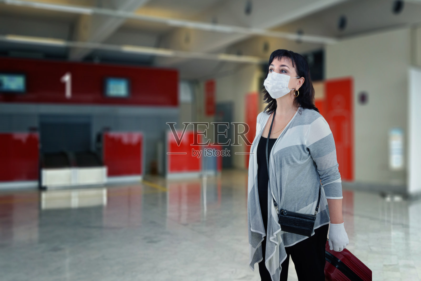 戴白色医用口罩和手套的女人正在寻找登记处照片摄影图片