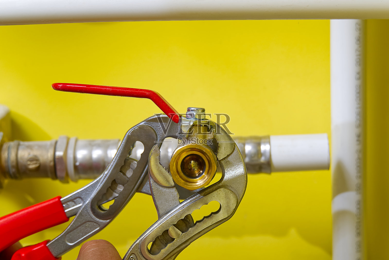 用钥匙连接水管配件。水管工在水槽上装了一个新的水管接头。照片摄影图片