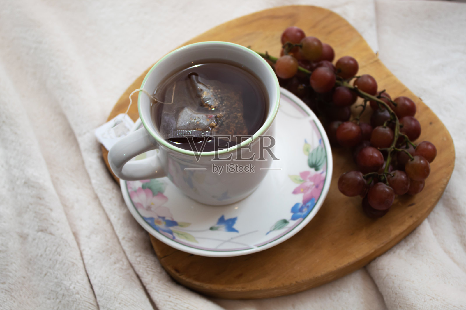 鲜花茶杯，葡萄和牡丹准备放松照片摄影图片