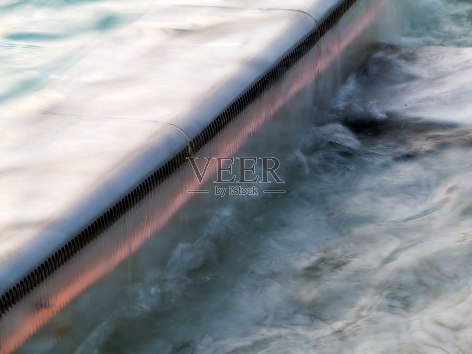 清澈和干净的水在池的背景。模糊的表面上的波浪。照片摄影图片