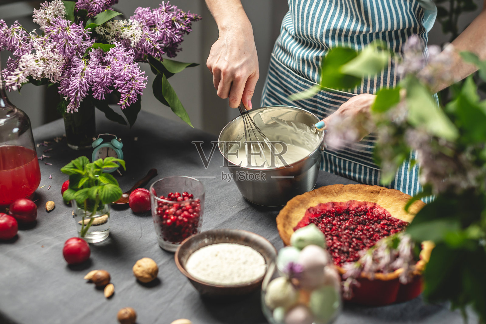 自制蔓越莓派。糕点师正在打一打酸奶油照片摄影图片