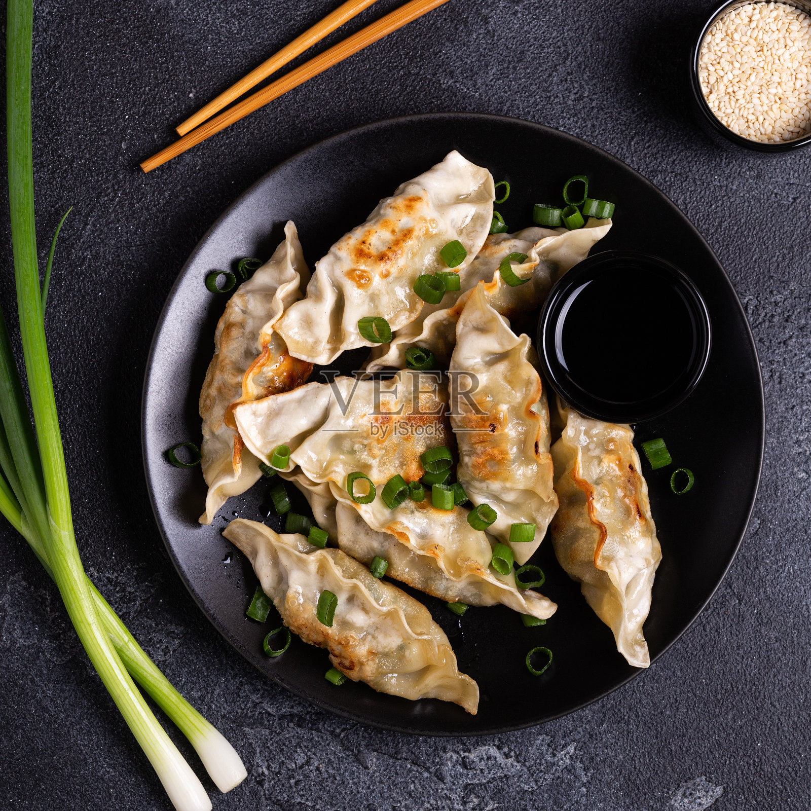 在灰色混凝土背景下的盘子上煎饺团子照片摄影图片