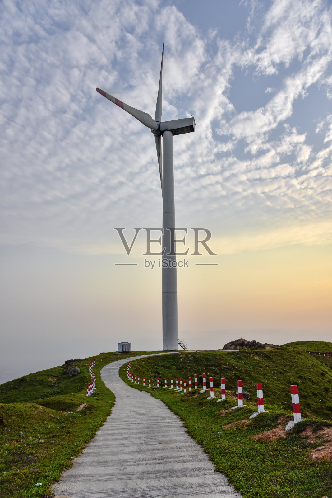 日出日落时风力发电水泥路。照片摄影图片