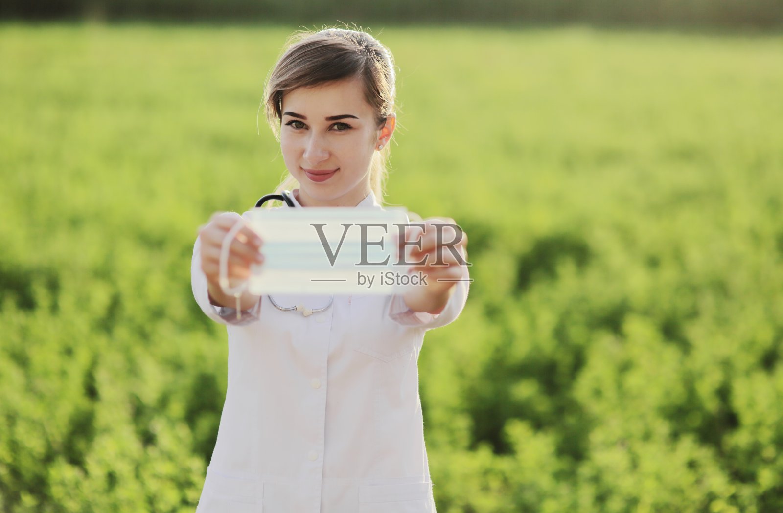 近距离展示医用口罩的年轻女医生或护士照片摄影图片