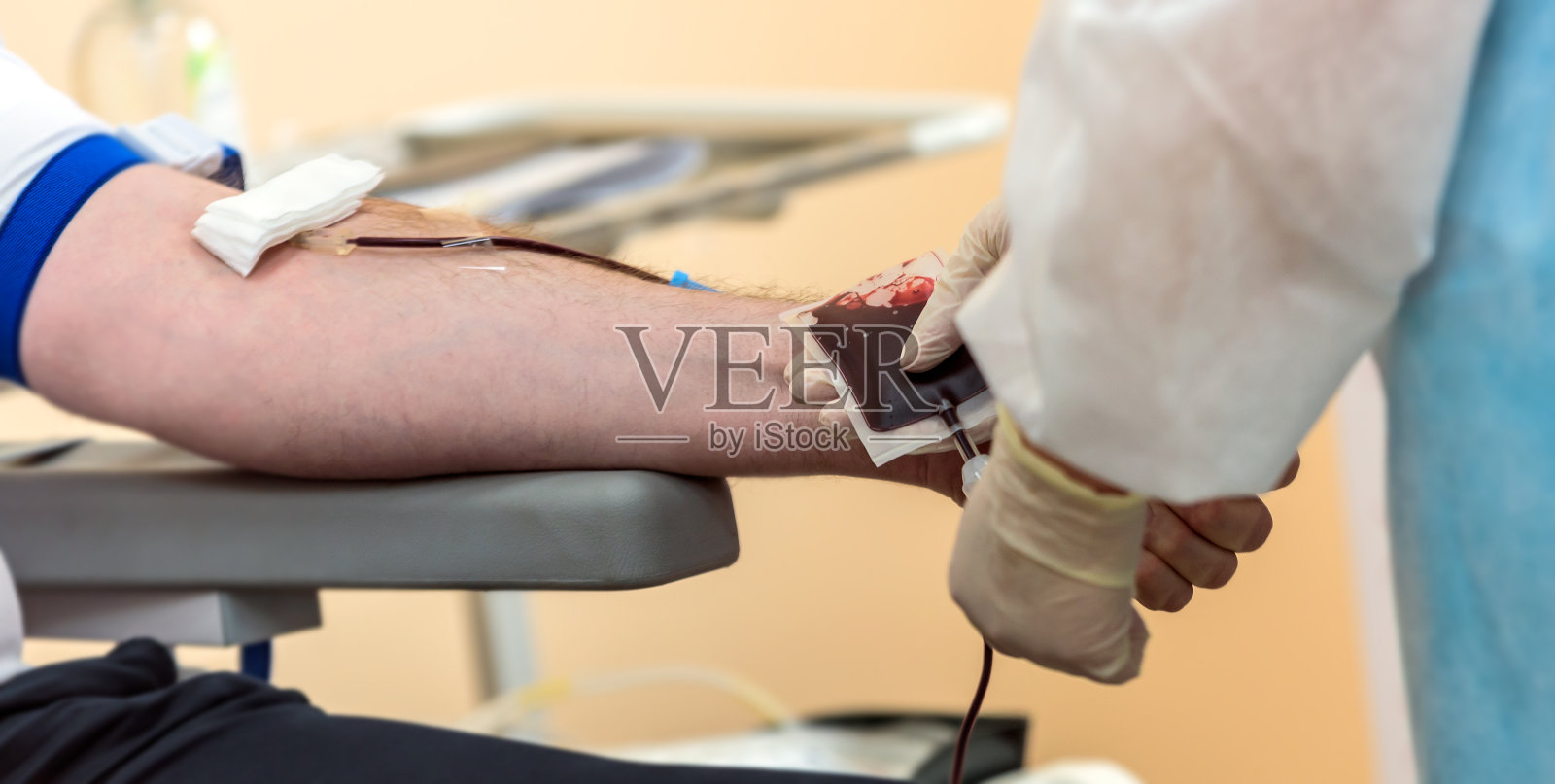 献血者手拿弹力球在献血。照片摄影图片