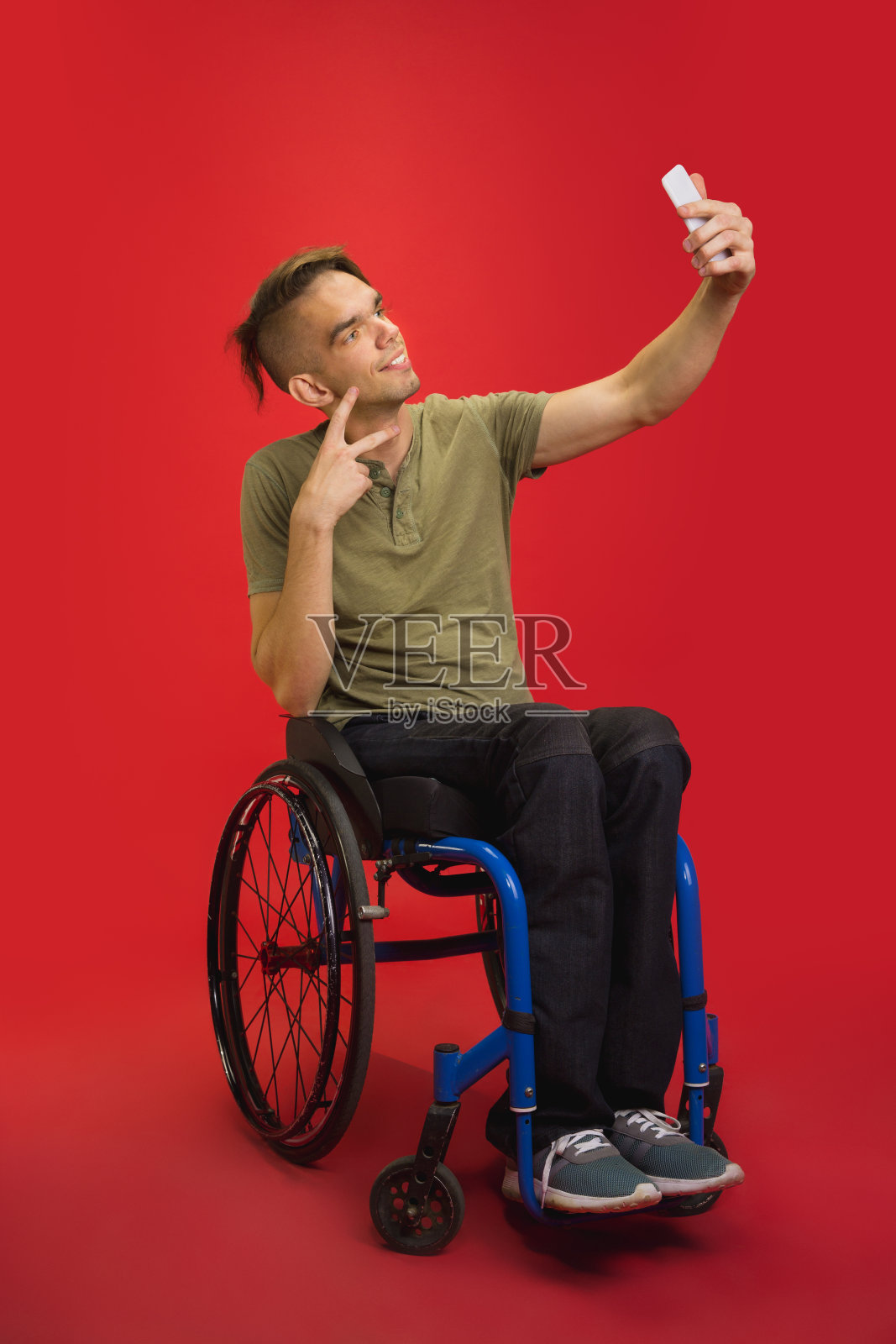 白人青年的肖像孤立在红色的工作室背景。人类情感的概念照片摄影图片