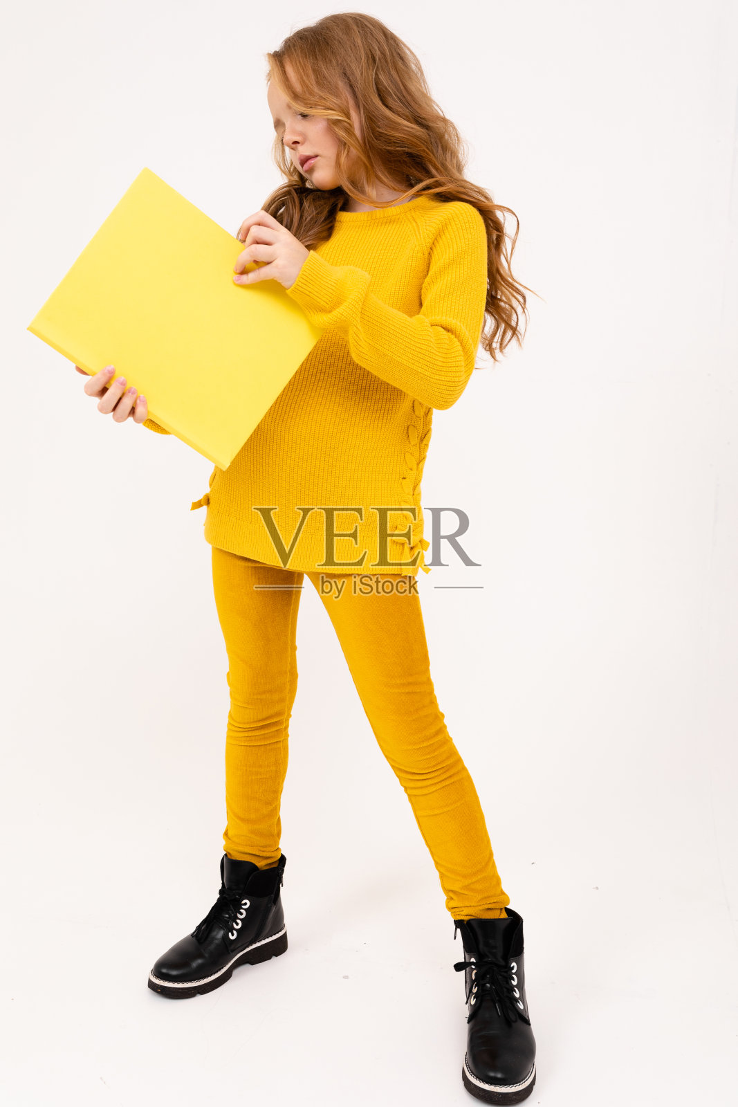 有魅力的女孩拿着一张白纸在白色的背景。照片摄影图片