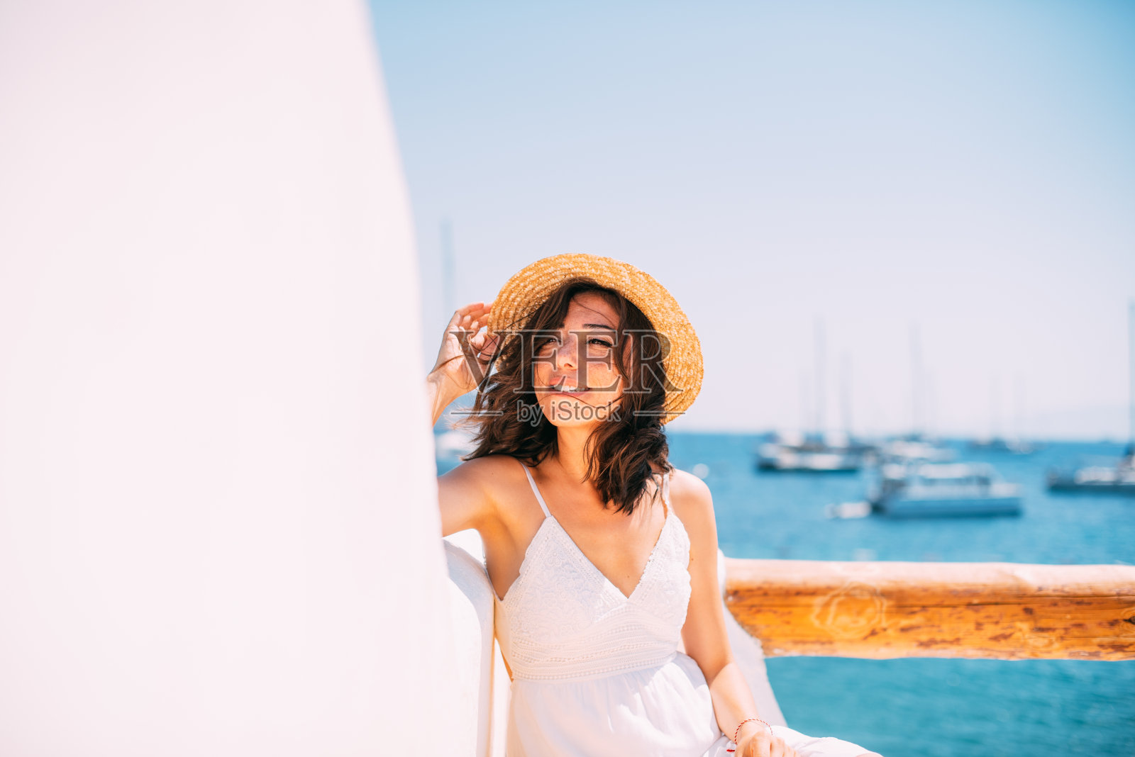 部落客女子身穿白裙，头戴草帽，享受阳光照片摄影图片