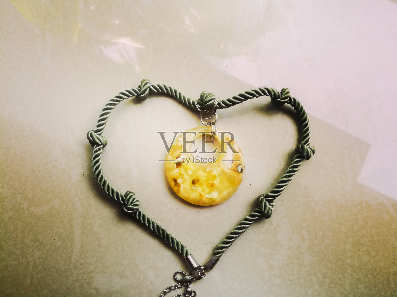 一种绳型的项链，上面有一个漂亮的小吊坠。照片摄影图片