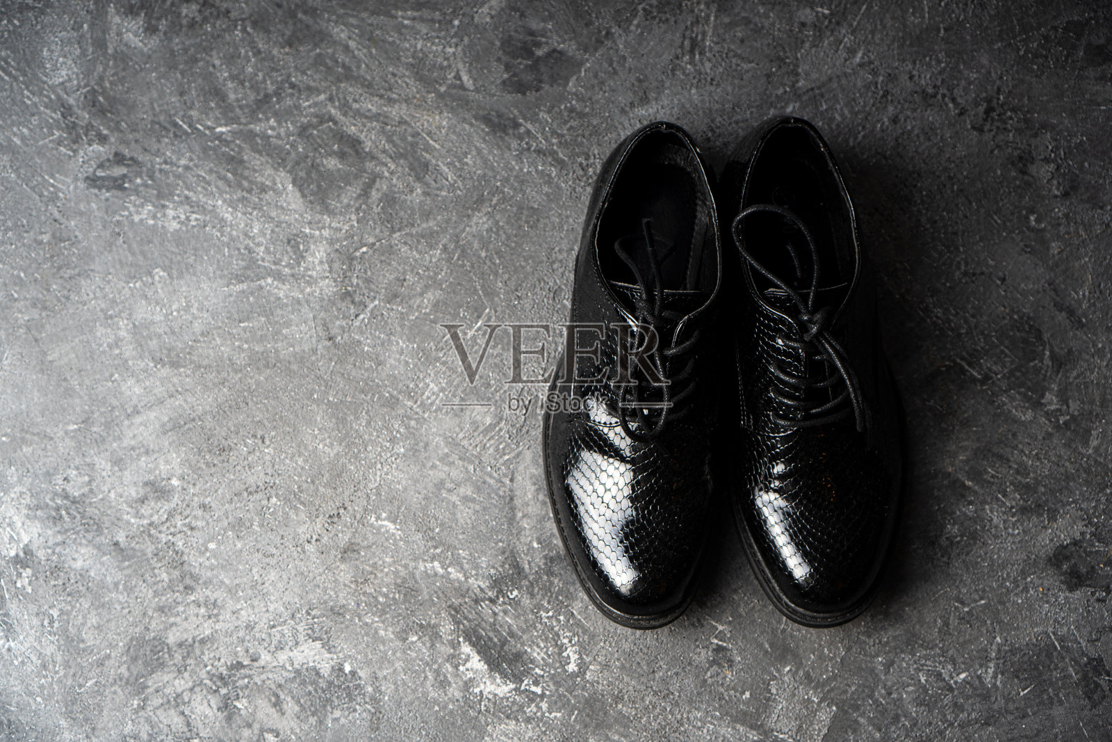 优雅的男女皆宜的黑色鞋子站在混凝土背景上。前视图。副本的空间。照片摄影图片