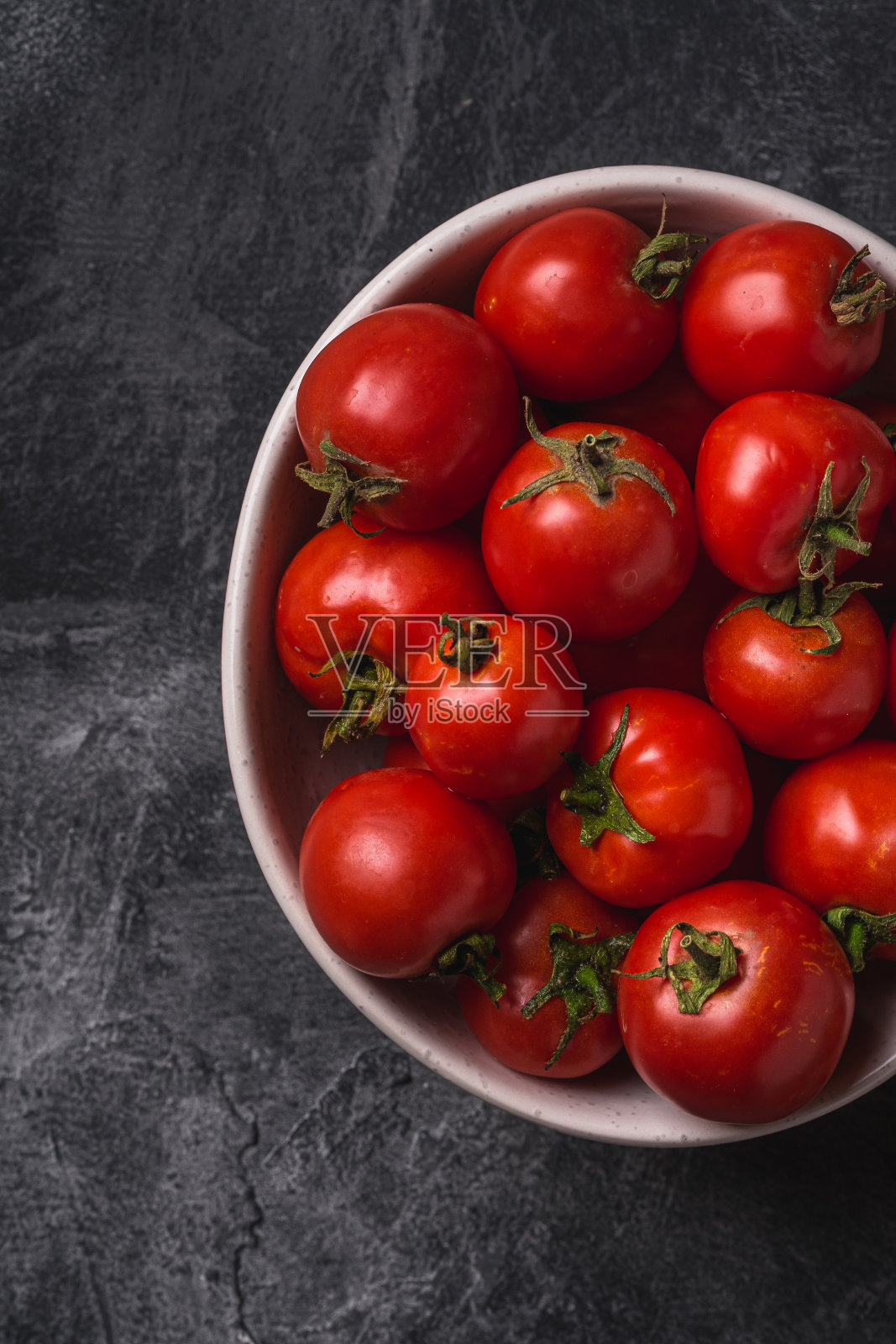 新鲜成熟的西红柿在碗中，在黑暗的混凝土背景，俯视图宏观照片摄影图片