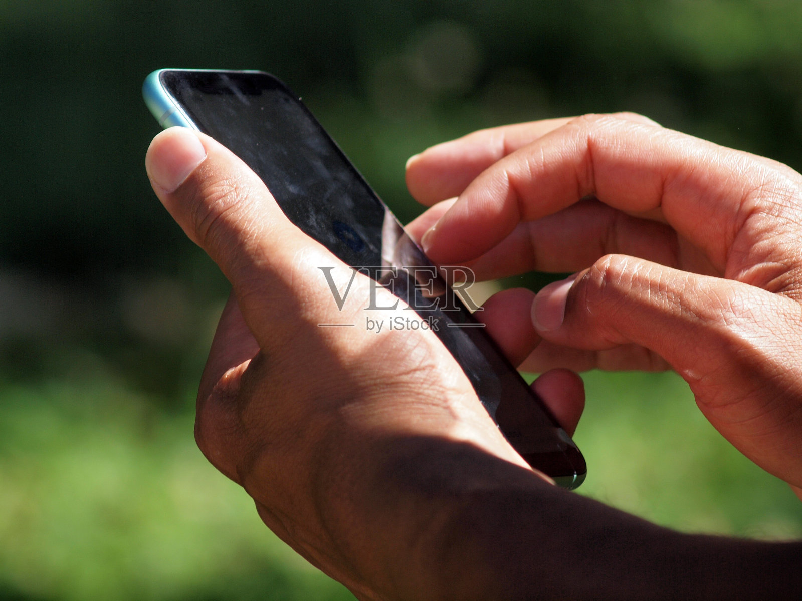男人的手在外面使用智能手机照片摄影图片