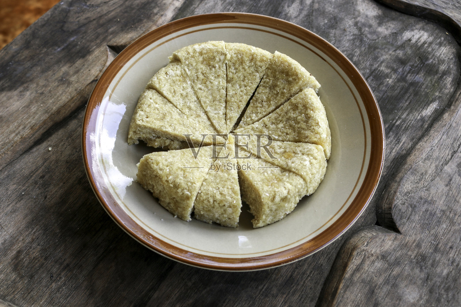 Krasikan是来自印尼Gunung Kidul的传统小吃蛋糕，由糯米、椰奶、红糖、椰丝做成，以木为背景。照片摄影图片