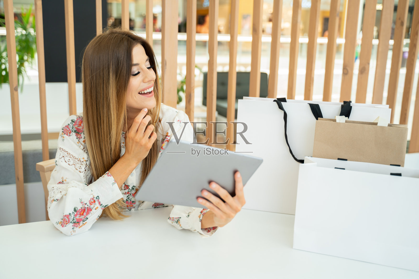 迷人的微笑女孩做网上购物平板电脑。照片摄影图片