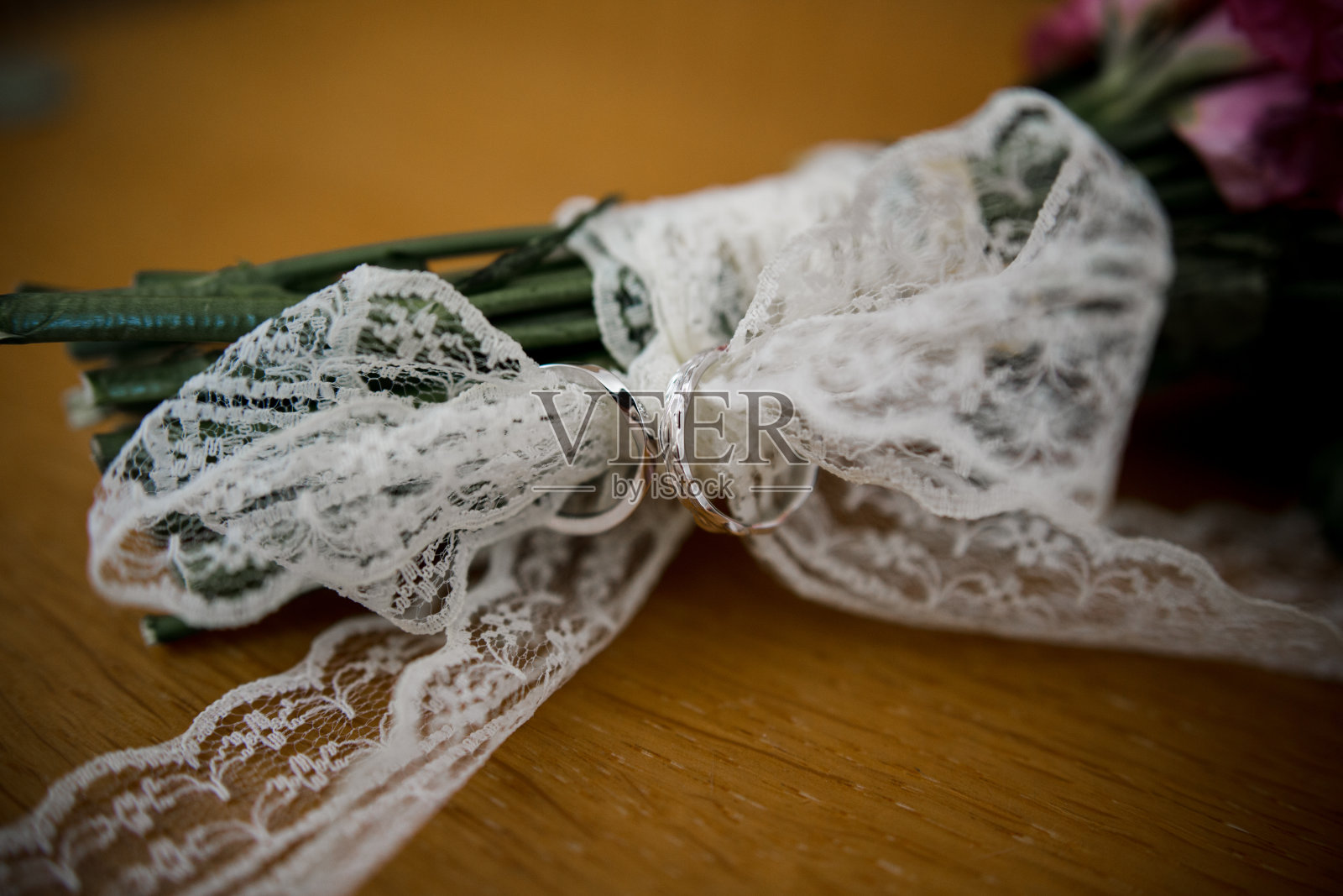 桌上放着婚戒和新娘花束照片摄影图片