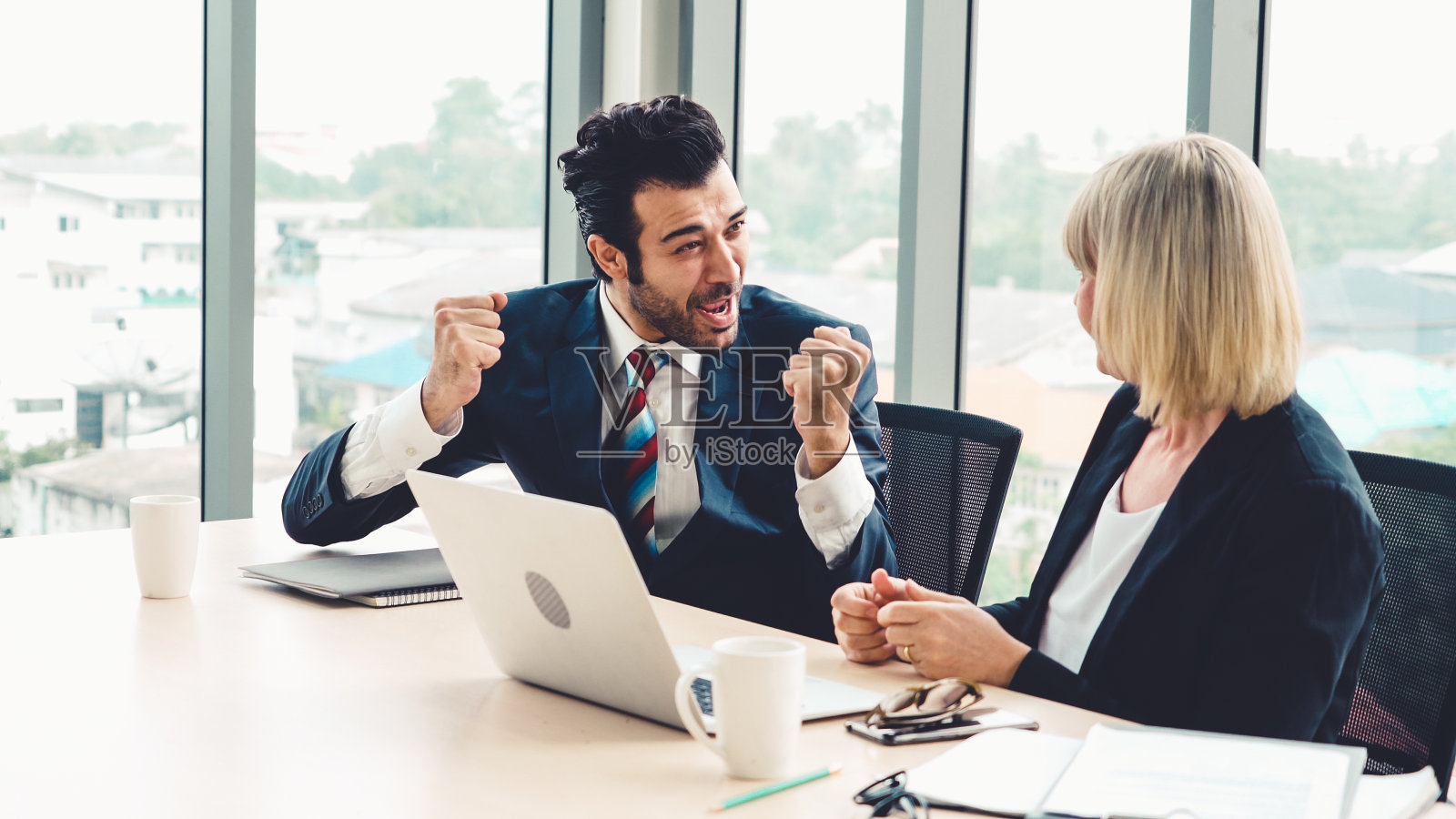 两个快乐的商业人士在办公室庆祝照片摄影图片