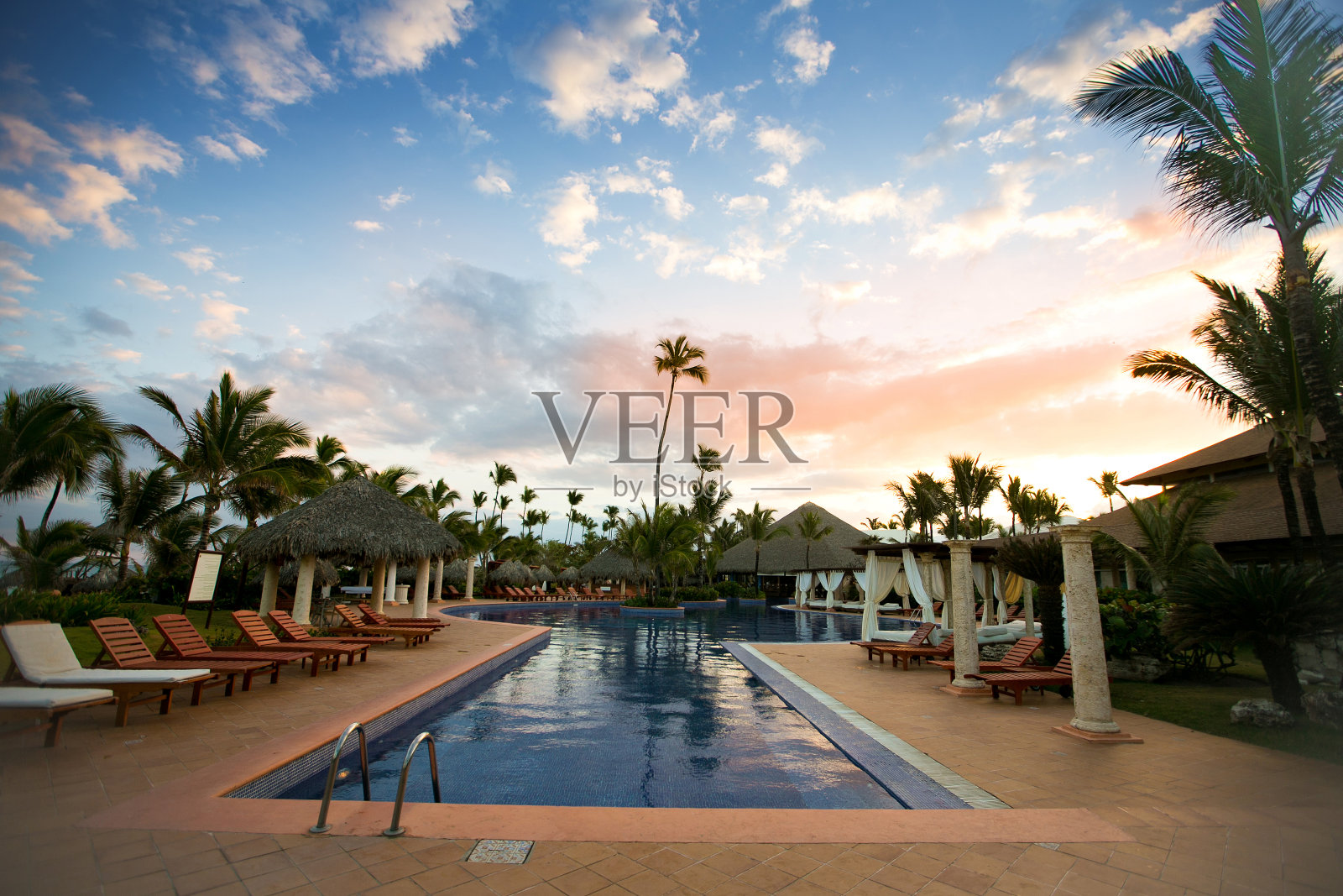 有日光浴躺椅的游泳池，没有游客。照片摄影图片