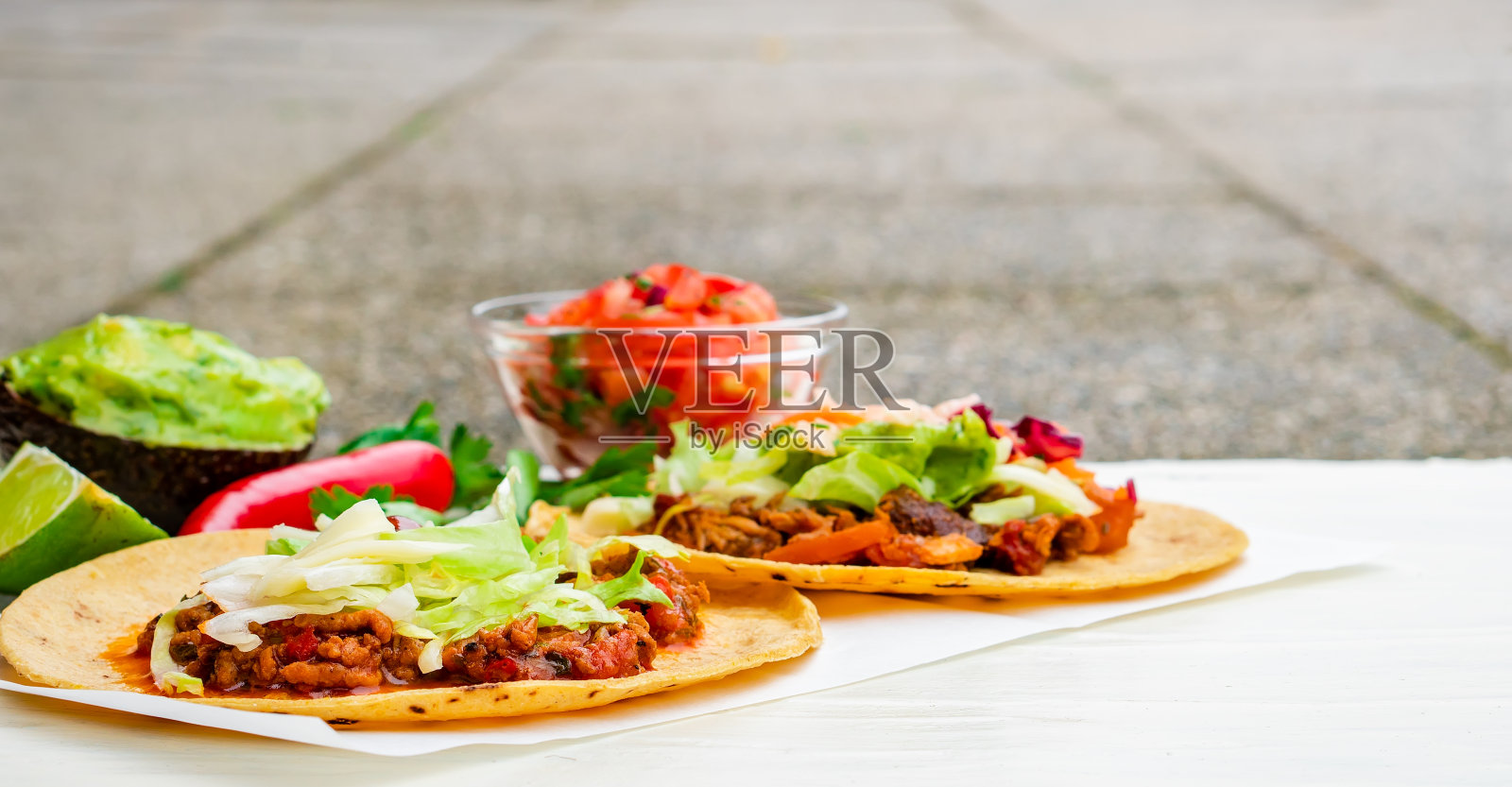 墨西哥传统的正宗自制玉米饼，猪肉牛肉辣椒肉酱配番茄沙拉，鳄梨鳄梨酱和蘸酱照片摄影图片